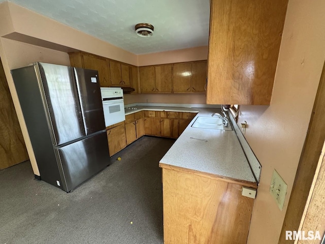 4528 5th St Unit B, East Moline, IL 61244 - kitchen with freestanding refrigerator, oven, a sink, brown cabinets, and light countertops