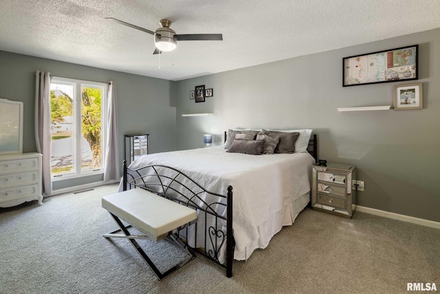 carpeted bedroom featuring a textured ceiling, visible vents, baseboards, and ceiling fan