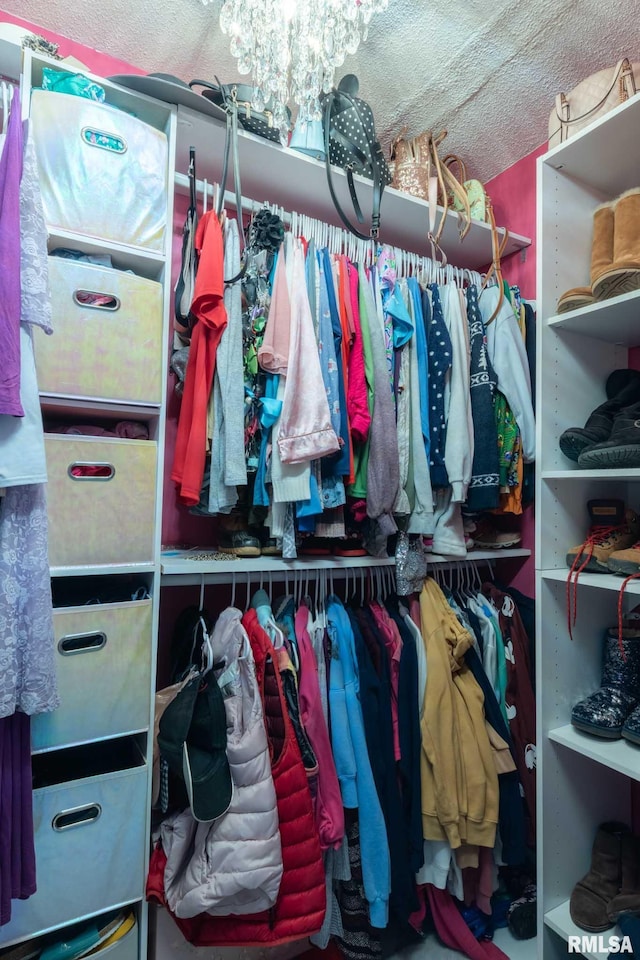 spacious closet featuring an inviting chandelier
