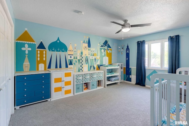 carpeted bedroom featuring ceiling fan and a textured ceiling