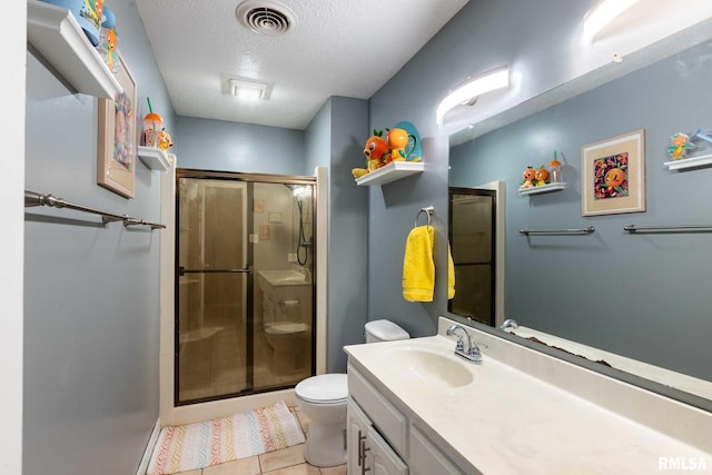 full bathroom with a stall shower, a textured ceiling, toilet, visible vents, and vanity