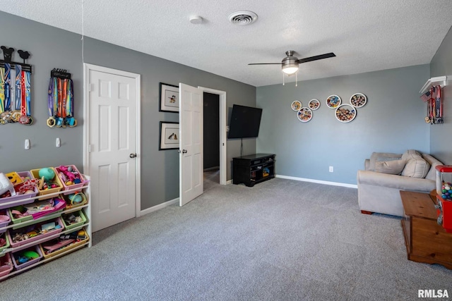 interior space featuring a textured ceiling, baseboards, carpet flooring, ceiling fan, and visible vents