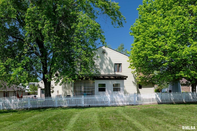 back of property with a fenced front yard and a yard
