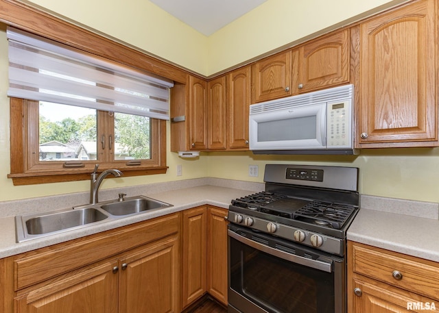 3418 25th St, Rock Island, IL 61201 - kitchen with stainless steel gas range oven, white microwave, a sink, light countertops, and brown cabinetry