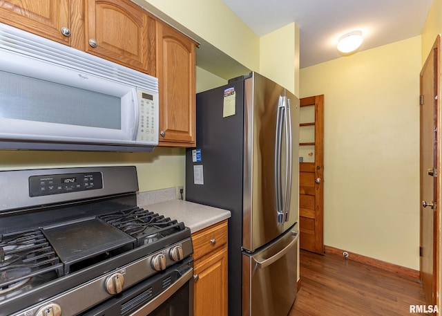3418 25th St, Rock Island, IL 61201 - kitchen featuring stainless steel appliances, wood finished floors, light countertops, and brown cabinets