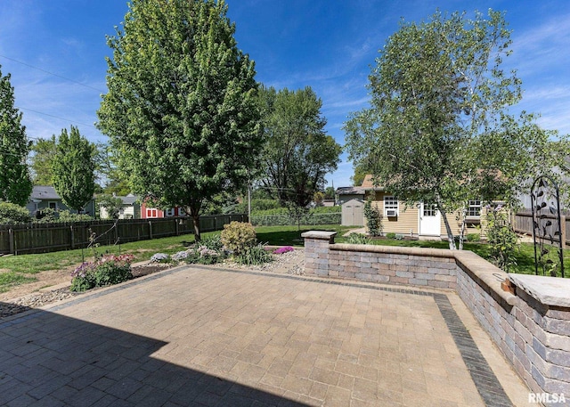 3418 25th St, Rock Island, IL 61201 - view of patio featuring an outdoor structure, a fenced backyard, and a storage shed