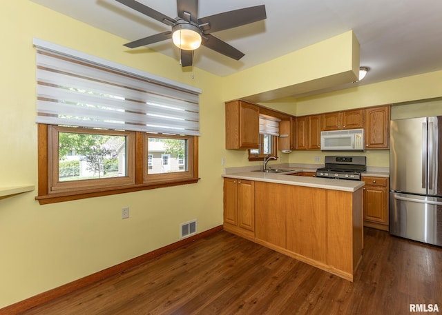 3418 25th St, Rock Island, IL 61201 - kitchen featuring stainless steel appliances, a sink, light countertops, and dark wood-style floors