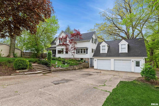 view of front of property featuring a detached garage and fence
