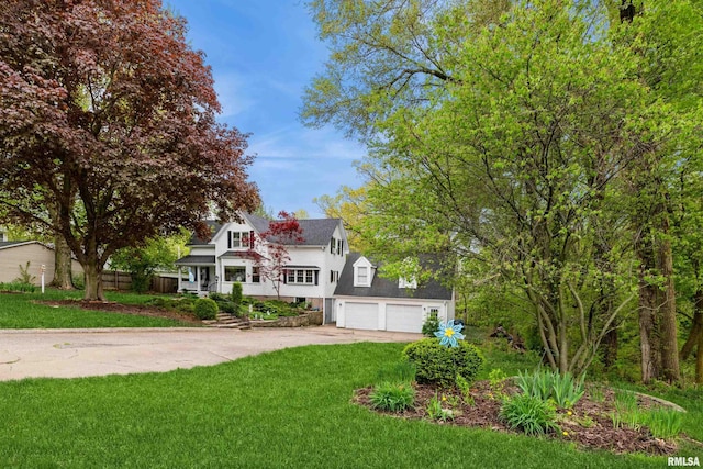 view of front of home featuring an attached garage, driveway, and a front yard