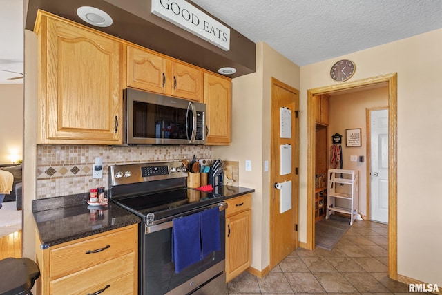 kitchen with stainless steel appliances, tasteful backsplash, light tile patterned flooring, and light brown cabinetry