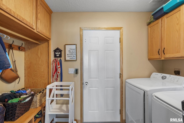laundry area with a textured ceiling, cabinet space, and independent washer and dryer