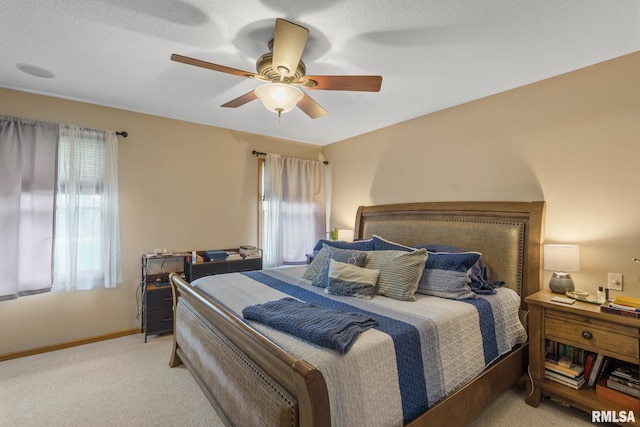 bedroom with baseboards, multiple windows, light carpet, and ceiling fan