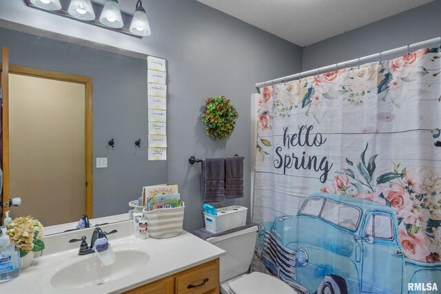 bathroom with toilet, vanity, and a textured ceiling
