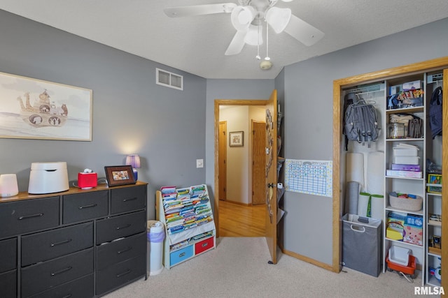 bedroom featuring light colored carpet, a closet, a ceiling fan, and visible vents