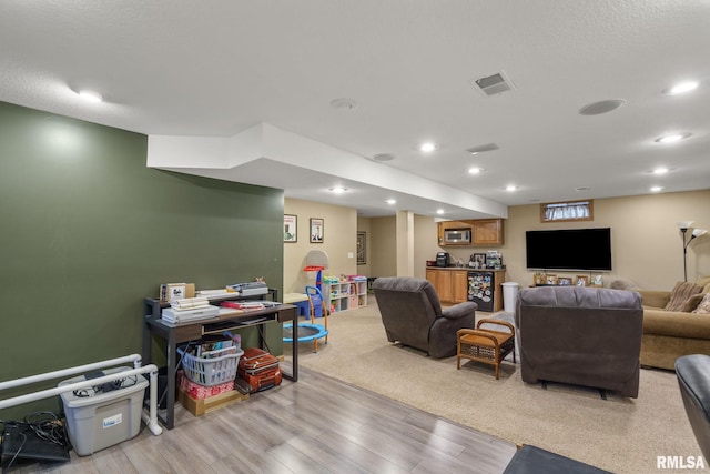living room featuring light wood-style floors, visible vents, and recessed lighting
