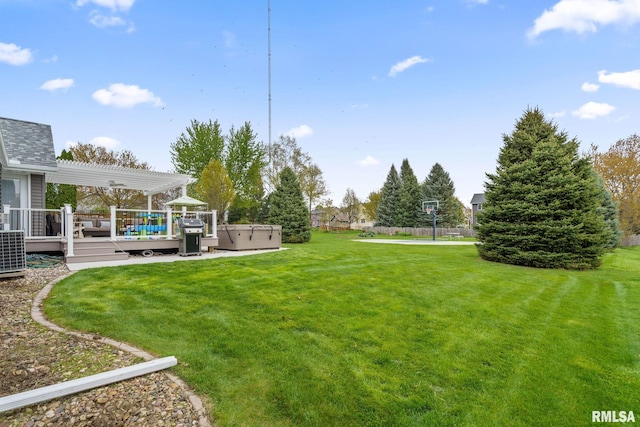 view of yard with a hot tub, a wooden deck, and a pergola