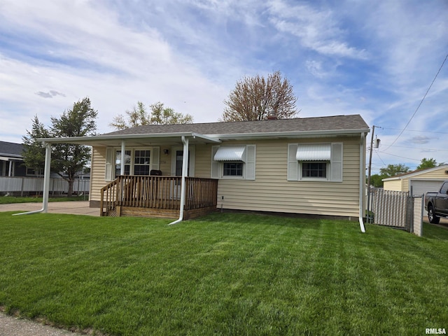view of front facade featuring a porch, roof with shingles, fence, and a front yard
