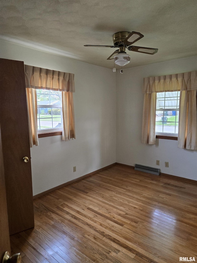 unfurnished room with baseboards, hardwood / wood-style floors, and ceiling fan
