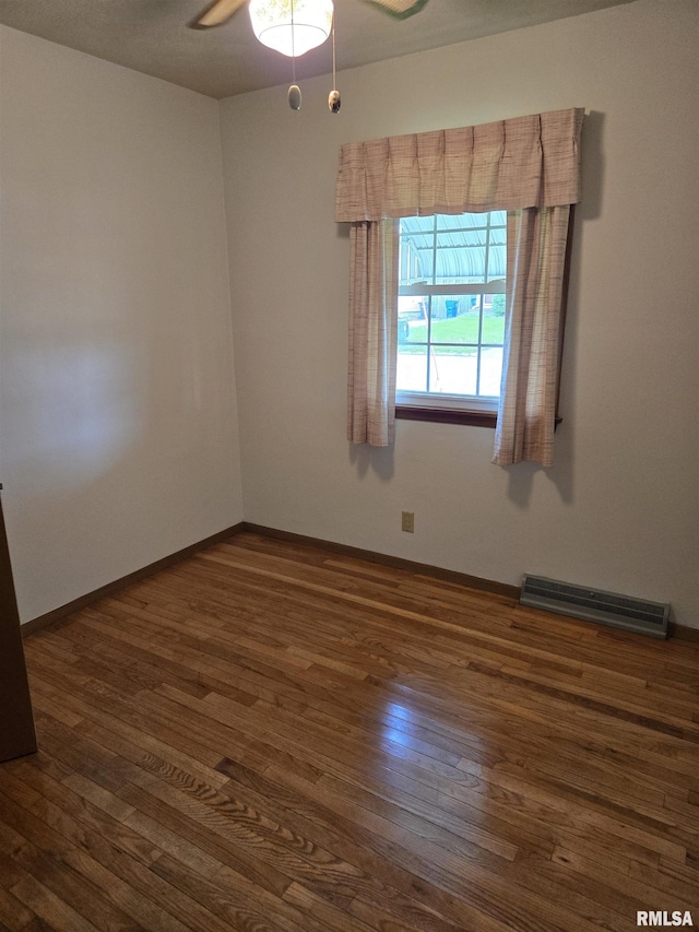 empty room with visible vents, baseboards, a ceiling fan, and hardwood / wood-style floors