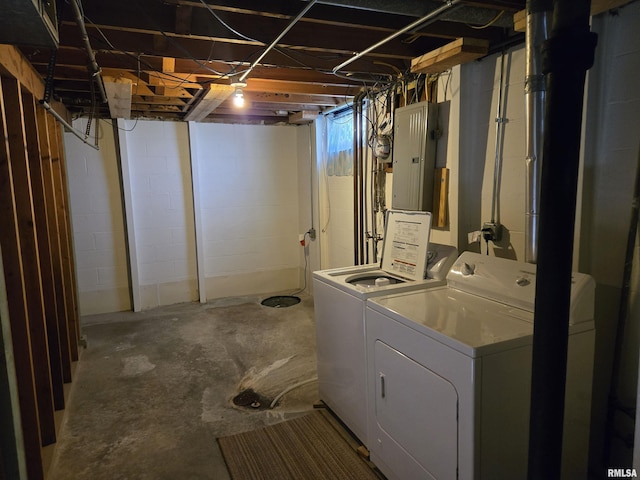 unfinished below grade area featuring electric panel and washer and clothes dryer