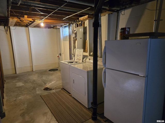 unfinished below grade area with freestanding refrigerator, washer and dryer, and electric panel
