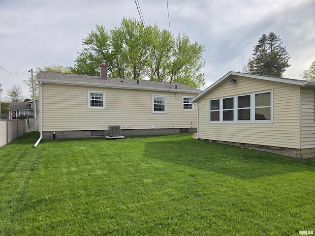 rear view of property with a yard, fence, and cooling unit