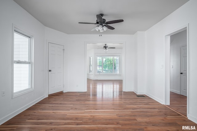 spare room featuring ceiling fan, baseboards, and wood finished floors