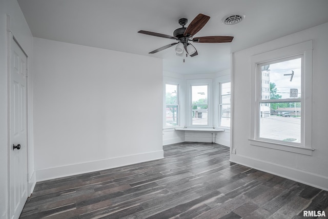 interior space featuring dark wood-style flooring, baseboards, ceiling fan, and visible vents