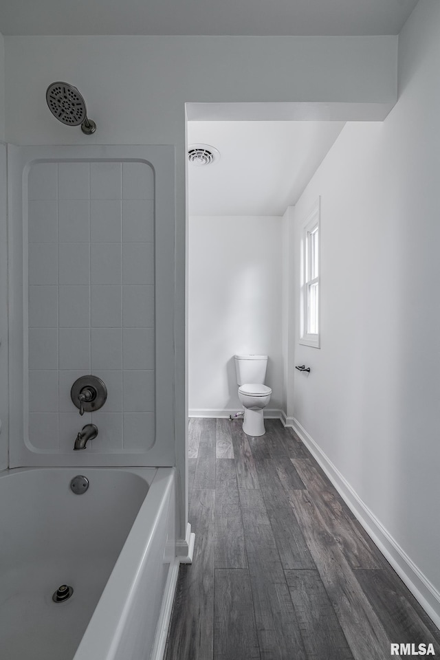full bathroom featuring toilet, baseboards, visible vents, tub / shower combination, and wood finished floors