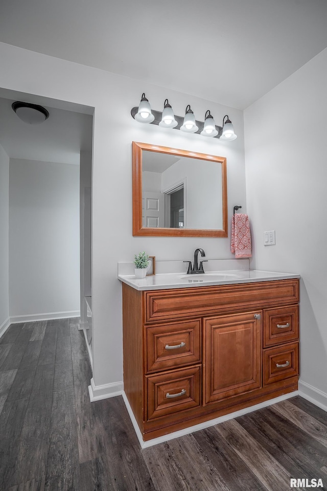 bathroom with baseboards, vanity, and wood finished floors