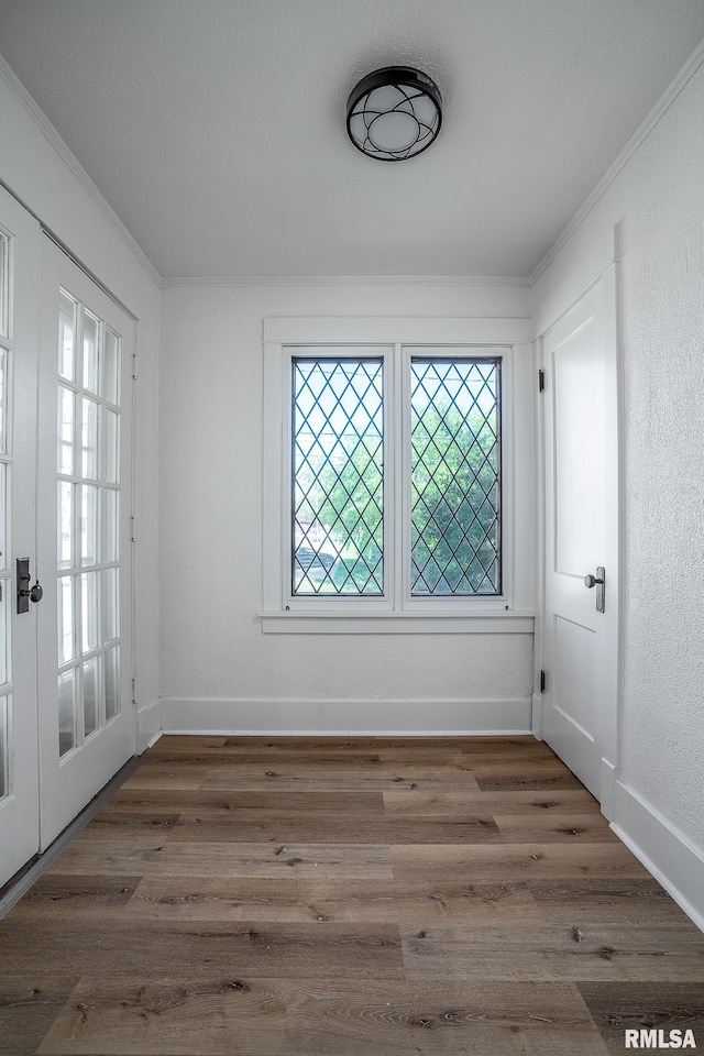 interior space featuring crown molding, wood finished floors, and baseboards