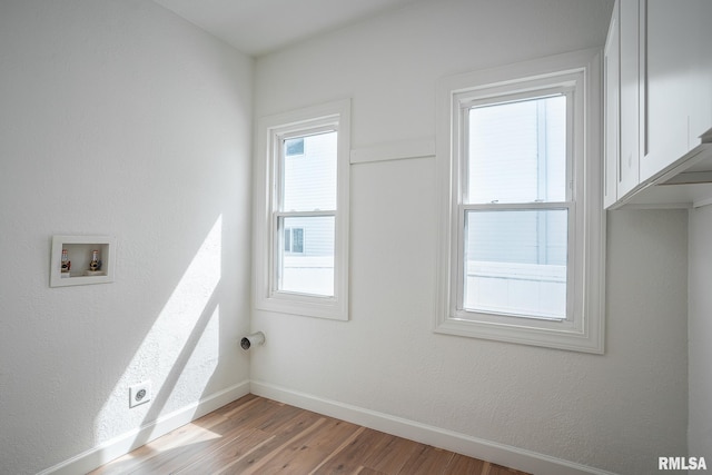 laundry room with washer hookup, light wood-type flooring, baseboards, and a healthy amount of sunlight