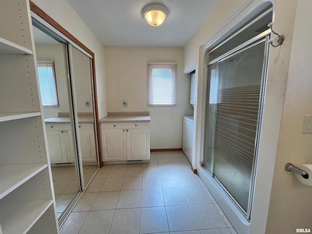 full bathroom featuring a stall shower, tile patterned flooring, and vanity