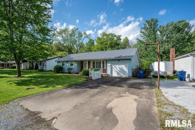 single story home featuring a front yard, aphalt driveway, a garage, and metal roof