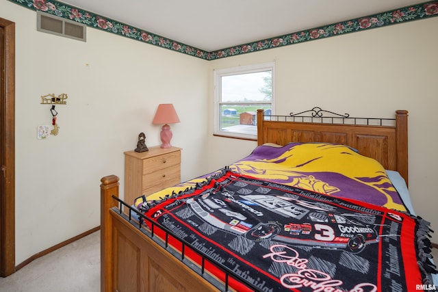 bedroom featuring visible vents, baseboards, and light carpet