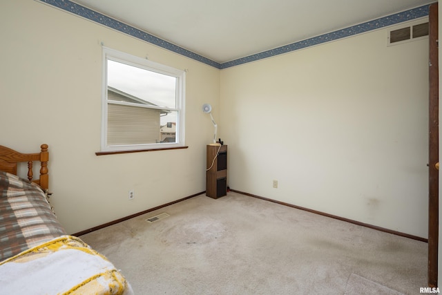unfurnished bedroom featuring carpet floors, baseboards, and visible vents