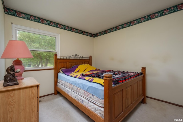 bedroom featuring light carpet and baseboards