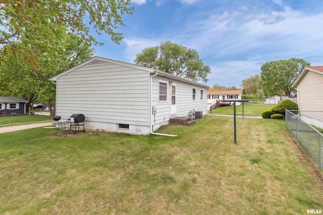 view of side of home featuring cooling unit, a yard, crawl space, and fence
