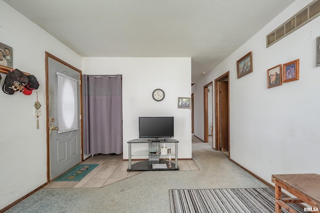 carpeted living area featuring baseboards and visible vents
