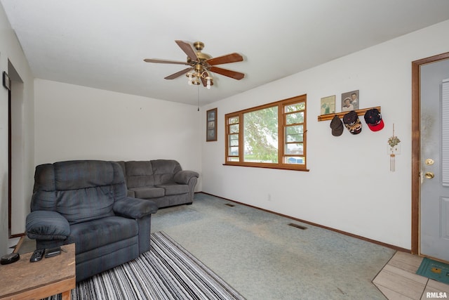 living room featuring baseboards, carpet flooring, visible vents, and ceiling fan