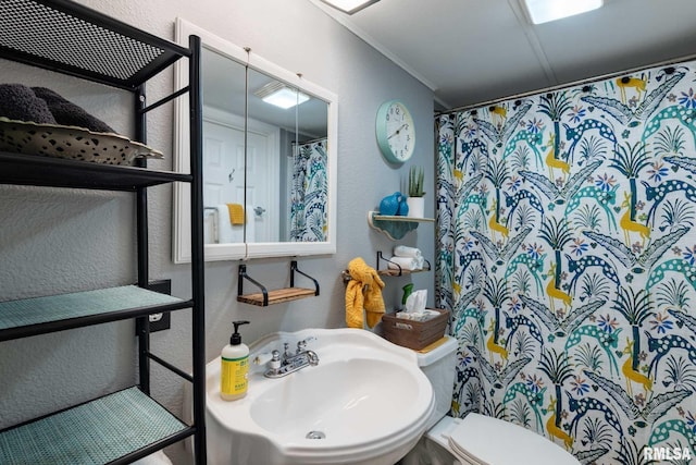 208 E Alexander St, Energy, IL 62933 - full bath featuring a textured wall, a sink, ornamental molding, toilet, and curtained shower