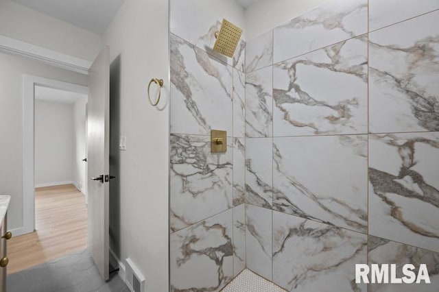 bathroom with visible vents and a tile shower