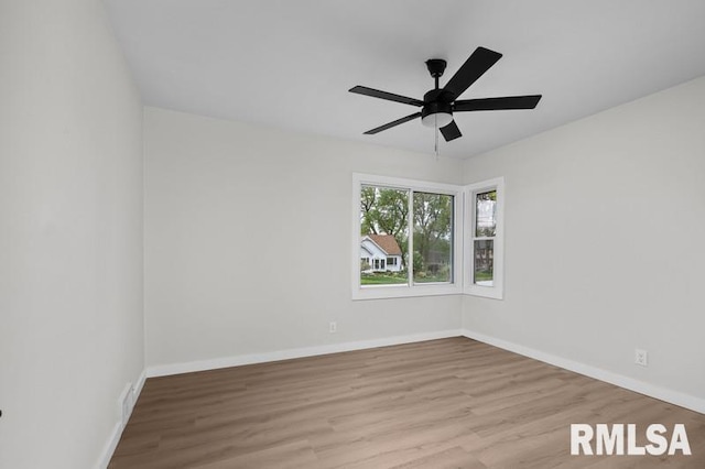 unfurnished room featuring baseboards, a ceiling fan, visible vents, and wood finished floors