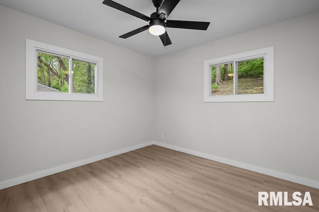 unfurnished room with a wealth of natural light, light wood-style flooring, and baseboards