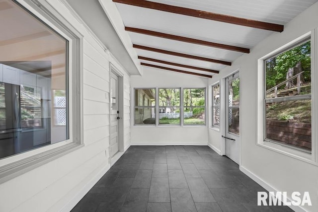 unfurnished sunroom with baseboards and vaulted ceiling with beams
