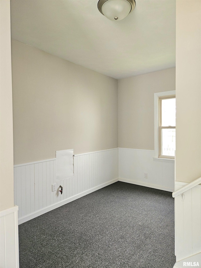 unfurnished room with wainscoting and carpet