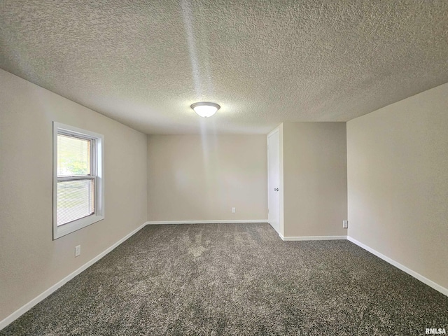 spare room with a textured ceiling, baseboards, and carpet floors