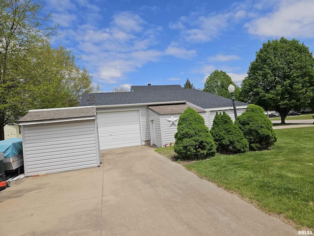 exterior space with a yard, concrete driveway, an attached garage, and a shingled roof