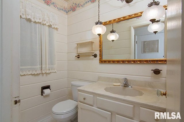half bathroom with vanity and toilet