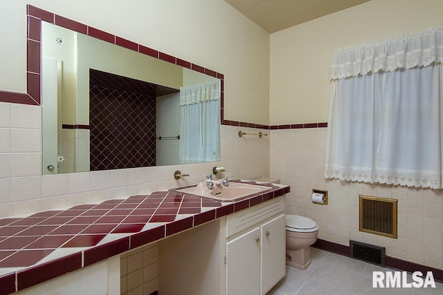 bathroom featuring tile walls, visible vents, and tile patterned floors